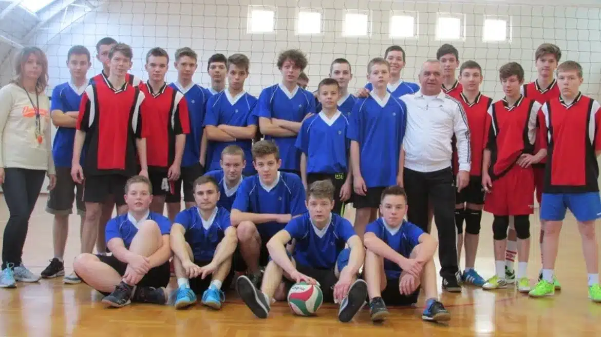 Na zdjęciu znajduje się grupa młodych zawodników oraz trenerów, którzy biorą udział w finałach powiatowych w siatkówce.