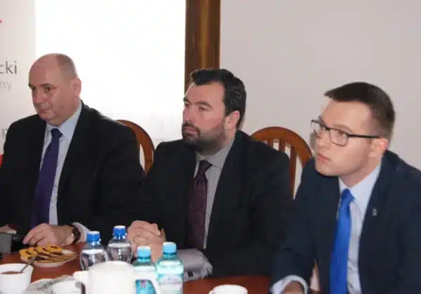 Na zdjęciu przedstawieni są mężczyźni podczas spotkania, na stole widoczne są napoje i przekąski, co sugeruje dyskusję w kontekście projektu e-tornistra na Mazowszu.