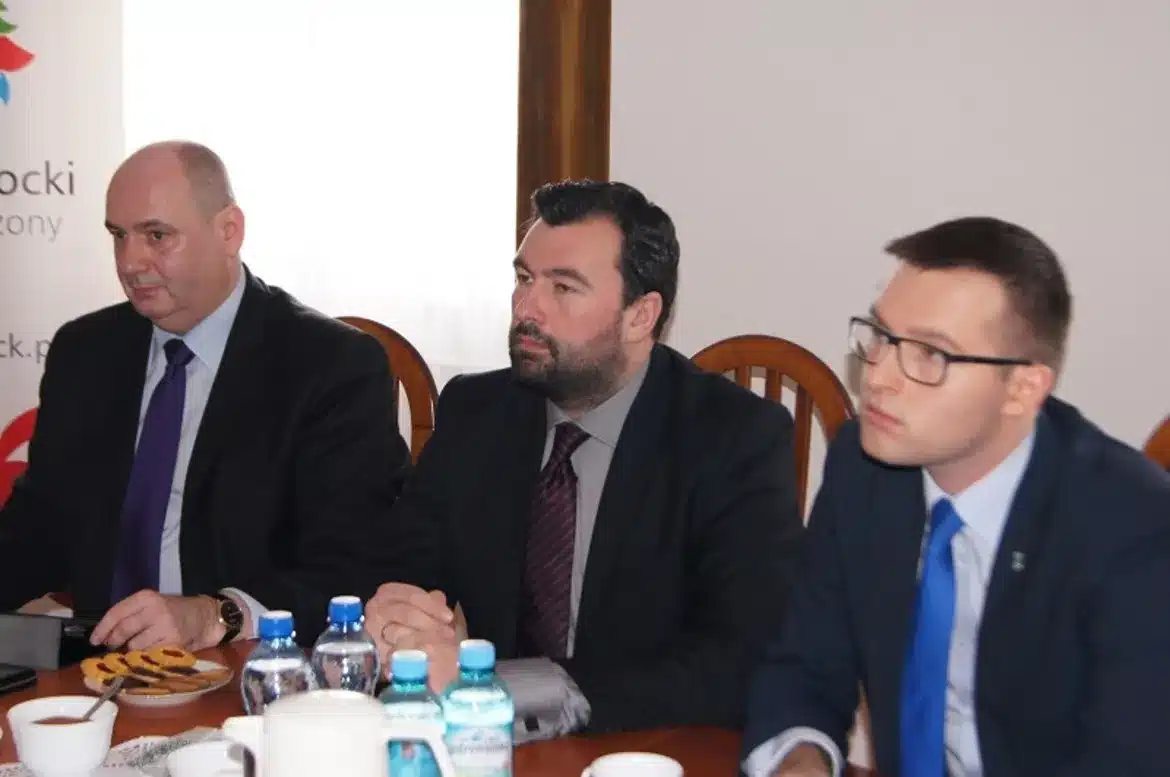 Na zdjęciu przedstawieni są mężczyźni podczas spotkania, na stole widoczne są napoje i przekąski, co sugeruje dyskusję w kontekście projektu e-tornistra na Mazowszu.