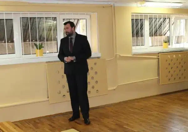 Na zdjęciu widoczny jest mężczyzna w garniturze, który przemawia podczas uroczystego otwarcia sali terapeutycznej „OAZA”.