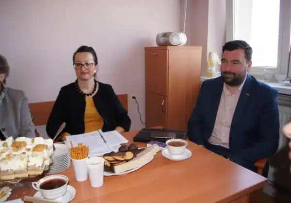 Na zdjęciu widać uczestników posiedzenia Powiatowej Społecznej Rady ds. Osób Niepełnosprawnych, siedzących przy stole z napojami i przekąskami.