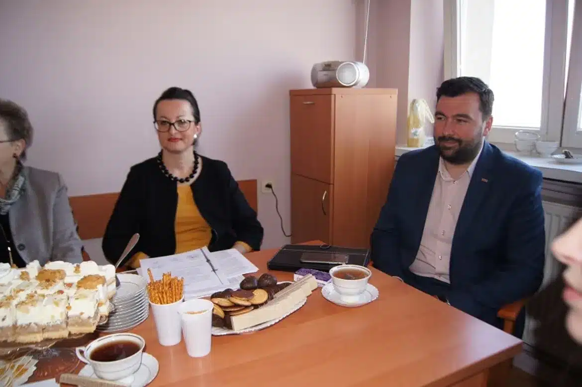 Na zdjęciu widać uczestników posiedzenia Powiatowej Społecznej Rady ds. Osób Niepełnosprawnych, siedzących przy stole z napojami i przekąskami.