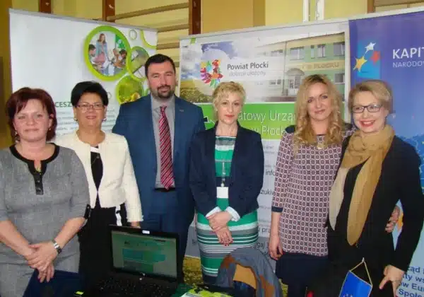 Na zdjęciu widać grupę osób stojących przy stoisku podczas VI Edycji Targów Edukacyjnych „Od edukacji do pracy” w Wyszogrodzie.