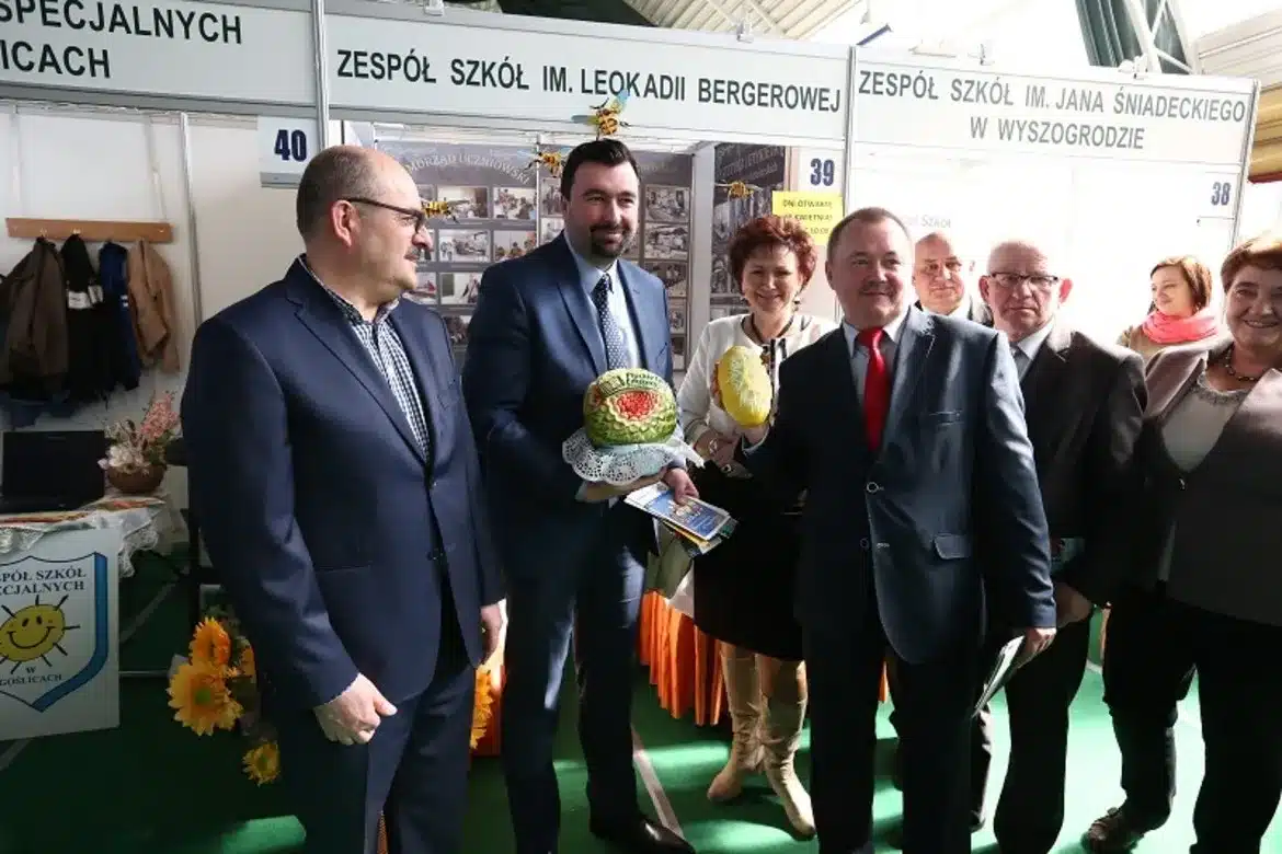 Na zdjęciu przedstawiono uczestników Płockich Targów Edukacyjnych, którzy pozują z efektownymi dekoracjami w kształcie owoców.