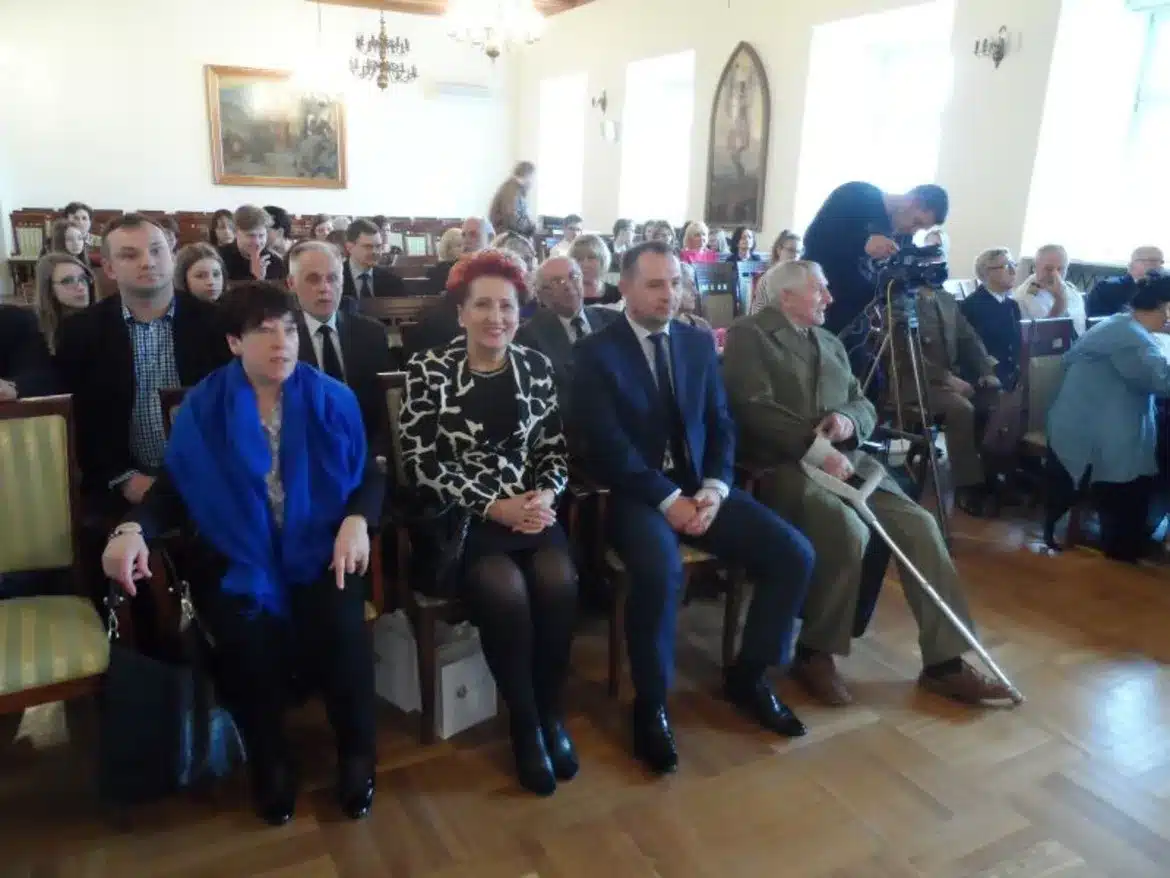 Uczestnicy wydarzenia związani z wręczeniem nagrody „O Szablę Komendanta” w sali udekorowanej tradycyjnymi elementami.