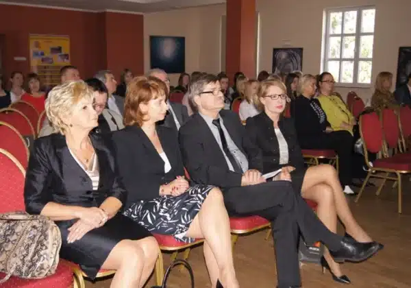 Uczestnicy konferencji siedzą na krzesłach w sali, biorąc udział w wydarzeniu poświęconym innowacyjnemu szkolnictwu zawodowemu na Mazowszu Płockim.