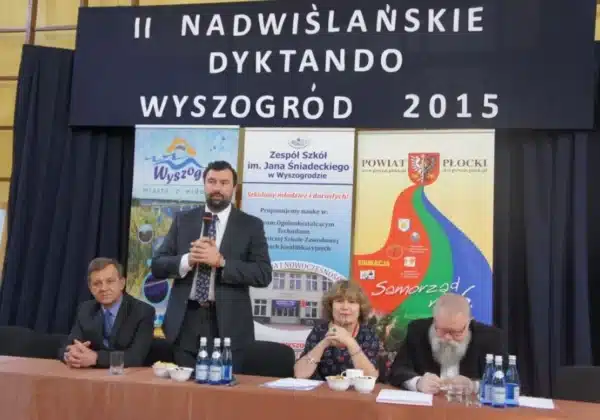 W trakcie II Nadwiślańskiego Dyktanda w Wyszogrodzie, na tle bannerów przedstawiających wydarzenie, cztery osoby siedzą przy stole, z jedną z nich występującą jako mówca.