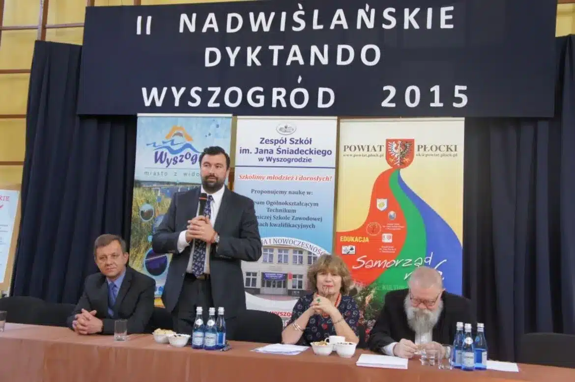 W trakcie II Nadwiślańskiego Dyktanda w Wyszogrodzie, na tle bannerów przedstawiających wydarzenie, cztery osoby siedzą przy stole, z jedną z nich występującą jako mówca.