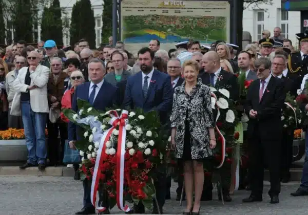 Obrazek przedstawia uczestników uroczystości z okazji 224. rocznicy uchwalenia Konstytucji 3 Maja, którzy składają kwiaty na tle zgromadzonej publiczności w Płocku.