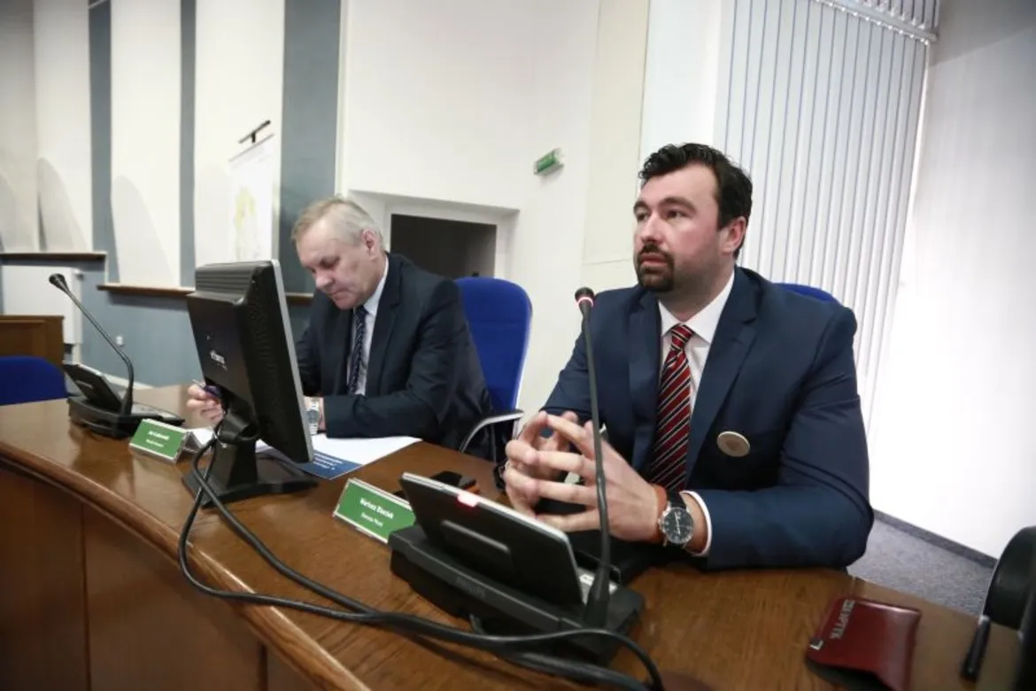 W sali obrad dwóch mężczyzn uczestniczy w dyskusji na temat koncepcji zagospodarowania przestrzennego miasta Płocka.