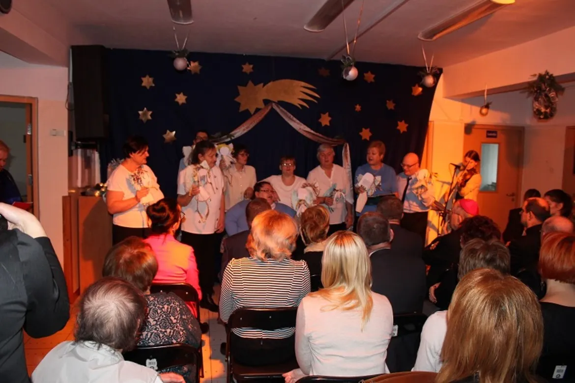 W Domu Pomocy Społecznej w Goślicach odbywa się wigilia, podczas której mieszkańcy i pracownicy wspólnie śpiewają i celebrują świąteczny czas.