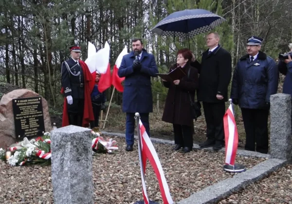 Uroczystość odsłonięcia kopca Bohaterów Powstania Styczniowego z udziałem lokalnych władz i mieszkańców, przy dźwiękach polskiej flagi i zaopatrzonych w parasole mówców.