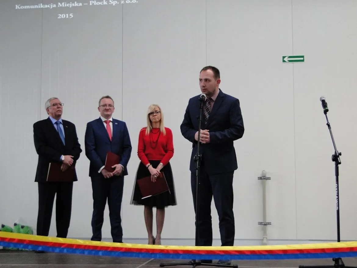 Uroczyste otwarcie hali usługowo-naprawczej Komunikacji Miejskiej w Płocku z przemawiającym mężczyzną oraz czterema osobami stojącymi obok.
