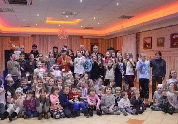 Uczestnicy strażackiej zabawy choinkowej w Wyszogrodzie pozują do zdjęcia w radosnej atmosferze.