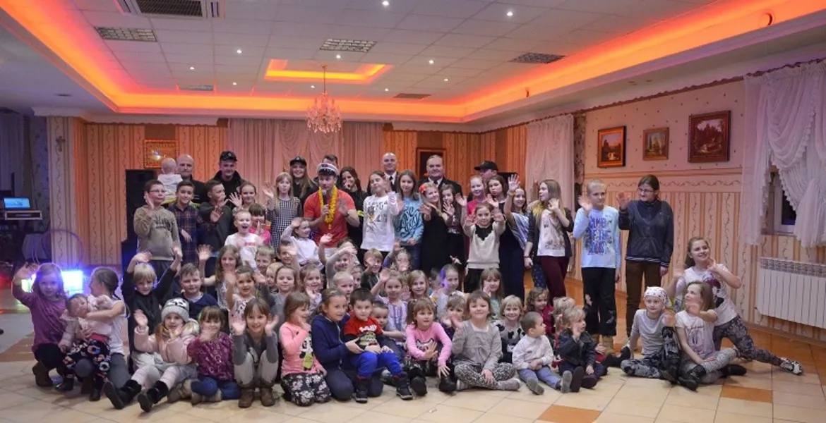 Uczestnicy strażackiej zabawy choinkowej w Wyszogrodzie pozują do zdjęcia w radosnej atmosferze.