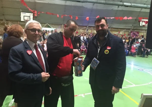 Na zdjęciu trzech mężczyzn uczestniczy w finale WOŚP, wręczając i odbierając datki w atmosferze wsparcia i charytatywnego zaangażowania.