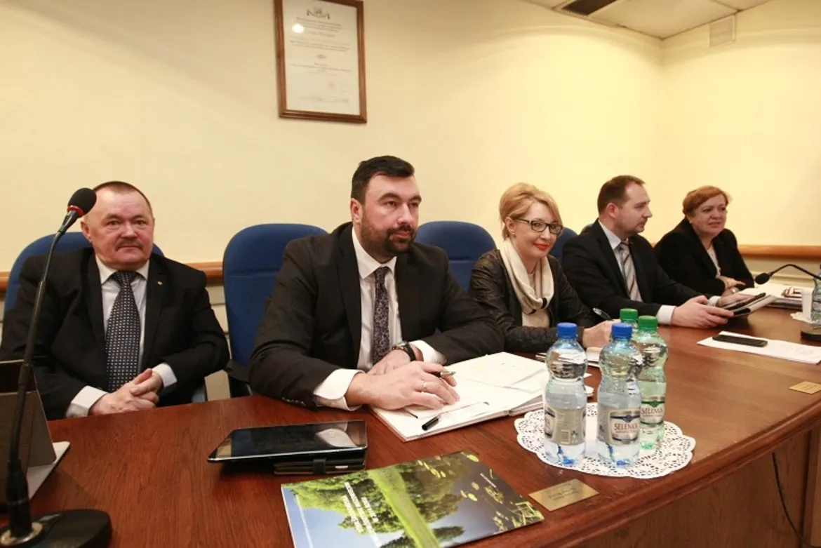 Na zdjęciu widać członków Rady Powiatu w Płocku podczas XII sesji w kadencji 2014-2018 z dokumentami i butelkami wody na stole.