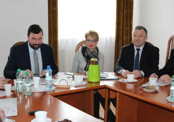 Posiedzenie Komisji Bezpieczeństwa i Porządku, w trakcie którego uczestnicy omawiają istotne kwestie, siedząc przy stole w jasnym pomieszczeniu.