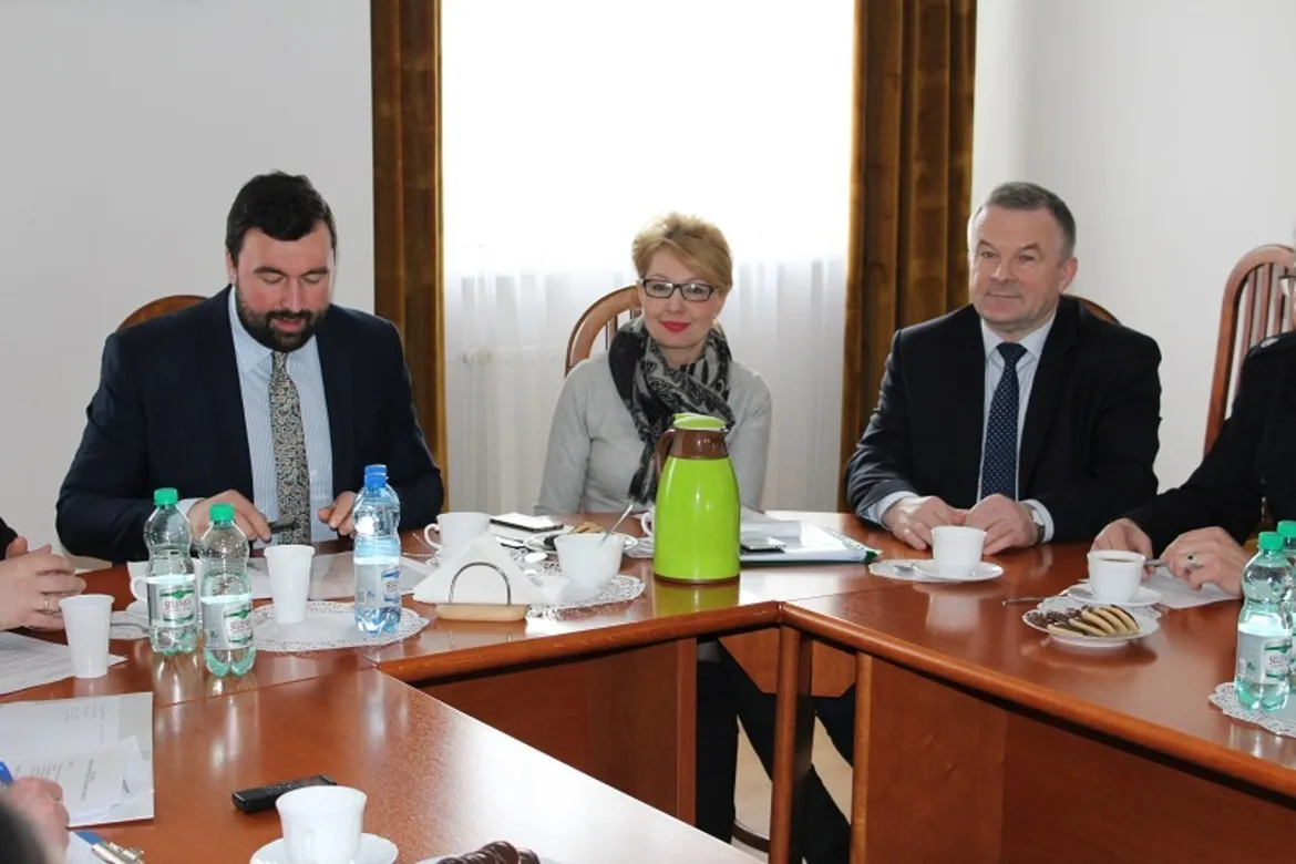 Posiedzenie Komisji Bezpieczeństwa i Porządku, w trakcie którego uczestnicy omawiają istotne kwestie, siedząc przy stole w jasnym pomieszczeniu.