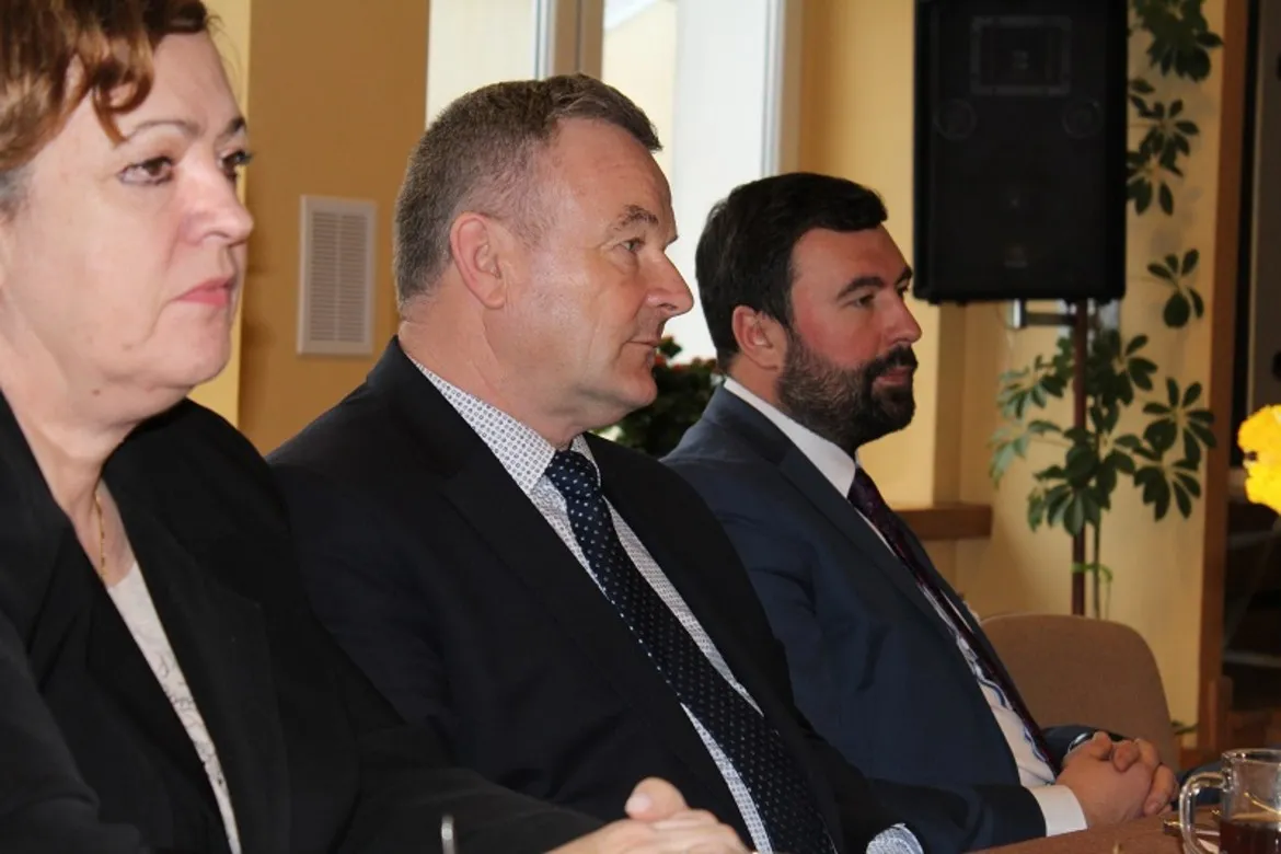 Na zdjęciu przedstawiono uczestników wyjazdowego posiedzenia Zarządu Powiatu w Płocku, siedzących przy stole.