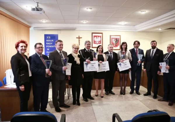 Na zdjęciu widoczna jest grupa osób uczestniczących w XIII sesji Rady Powiatu w Płocku, trzymających dyplomy i statuetki.