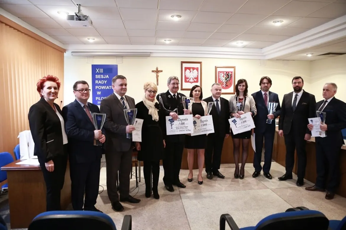 Na zdjęciu widoczna jest grupa osób uczestniczących w XIII sesji Rady Powiatu w Płocku, trzymających dyplomy i statuetki.