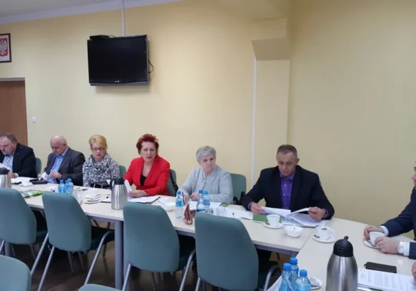 Posiedzenie Powiatowej Rady Zatrudnienia, podczas którego uczestnicy omawiają ważne kwestie dotyczące zatrudnienia przy stole zastawionym filiżankami i notatkami.