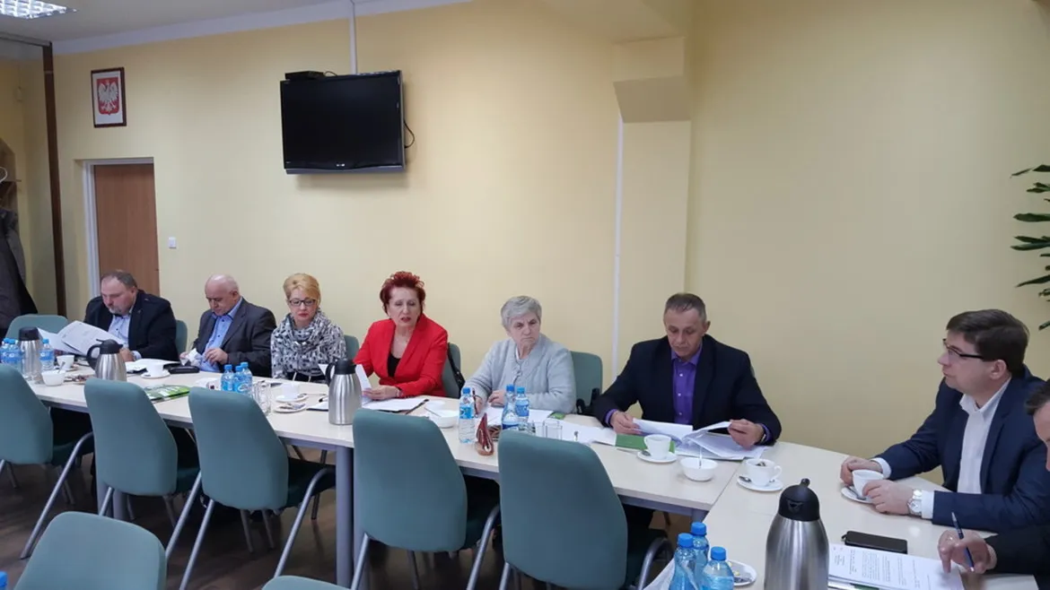 Posiedzenie Powiatowej Rady Zatrudnienia, podczas którego uczestnicy omawiają ważne kwestie dotyczące zatrudnienia przy stole zastawionym filiżankami i notatkami.