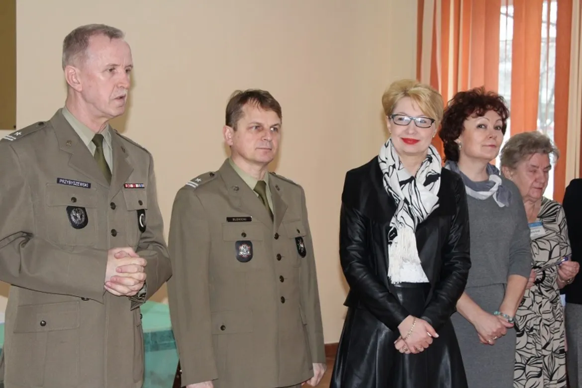 Na zdjęciu grupa osób, w tym żołnierze i przedstawiciele władz lokalnych, uczestniczy w inauguracji kwalifikacji wojskowej w powiecie płockim.