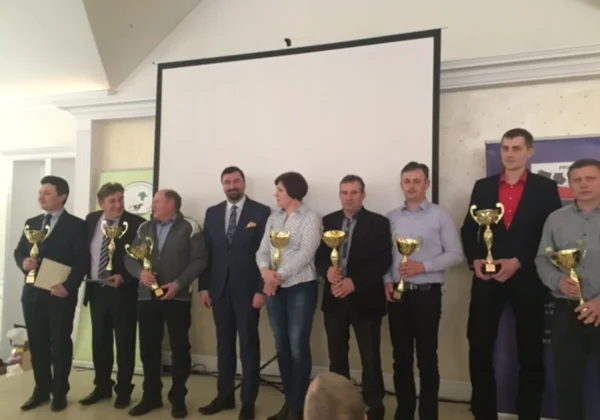 Podczas spotkania z Hodowcami Bydła i Producentami Mleka z terenu powiatu płockiego, uczestnicy stoją na scenie z pucharami w rękach.