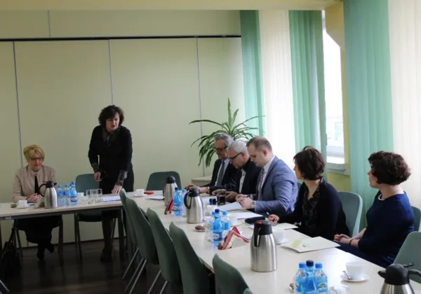 Spotkanie dotyczące bezrobocia w powiecie płockim, z udziałem kilku osób przy stole w sali konferencyjnej.