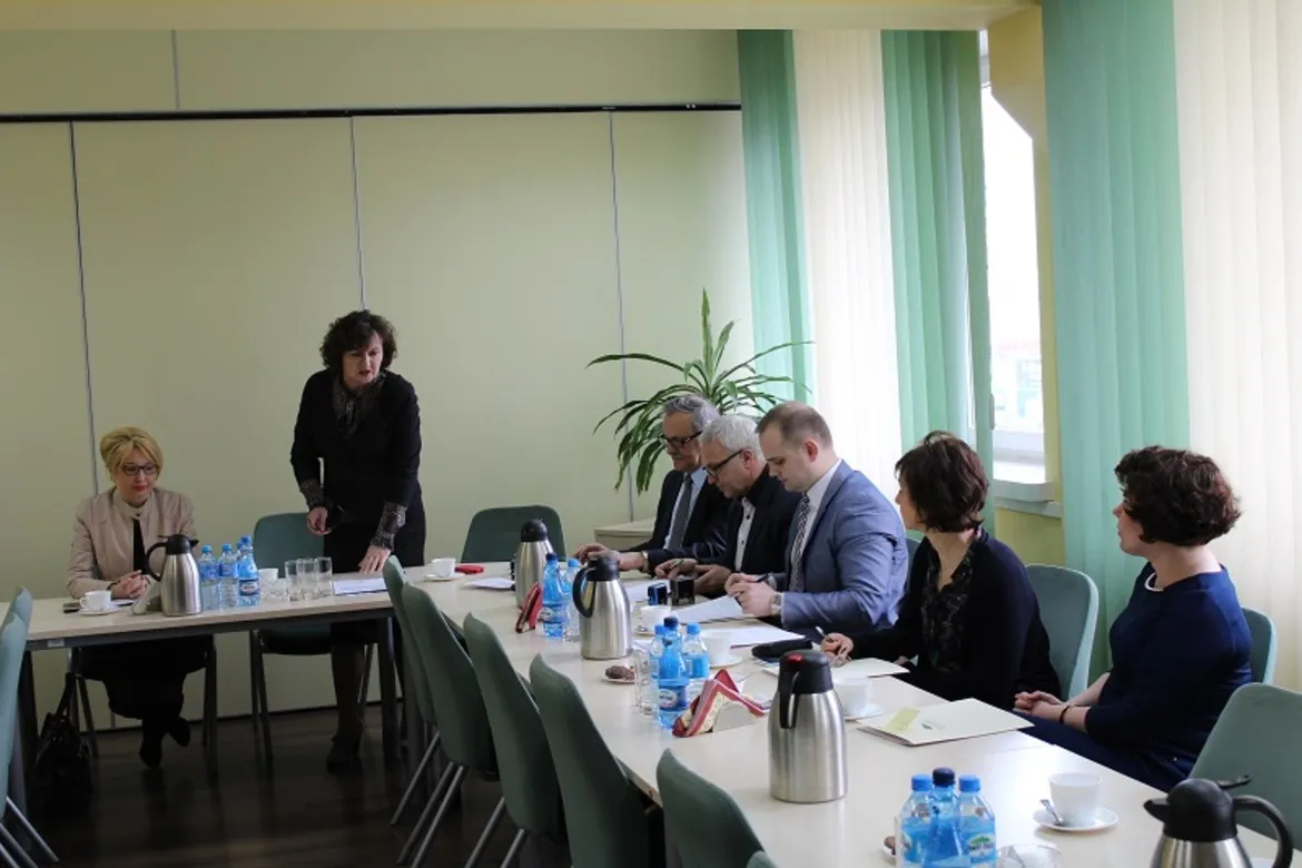 Spotkanie dotyczące bezrobocia w powiecie płockim, z udziałem kilku osób przy stole w sali konferencyjnej.