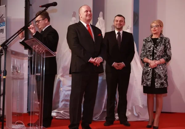 Na zdjęciu przedstawiono grupę ludzi stojących na scenie podczas rozstrzygania konkursu „Z Tumskiego Wzgórza”, z wyraźnymi oznakami ceremonii i uśmiechami na twarzach.