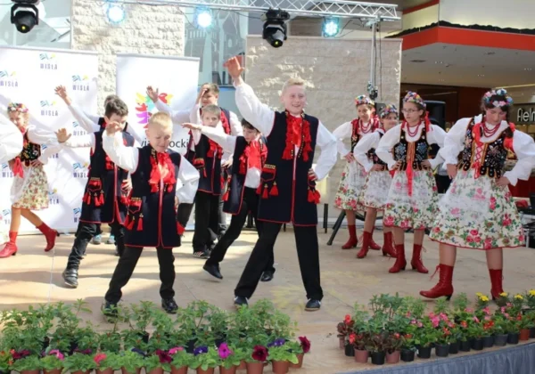Dzieci w tradycyjnych, kolorowych strojach ludowych tańczą na scenie podczas IV Festiwalu Zieleni w Galerii Wisła.