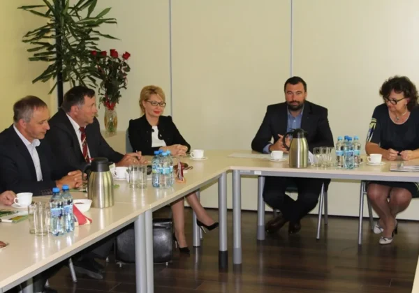 Grupa osób w formalnych ubraniach siedzi przy stołach w sali konferencyjnej podczas inauguracyjnego spotkania nowej kadencji Powiatowej Rady Rynku Pracy.