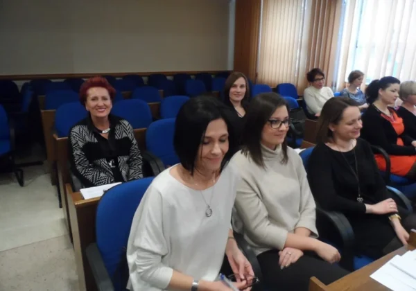 Kilka kobiet siedzi w sali wykładowej z niebieskimi fotelami, biorąc udział w godzinie wychowawczej.