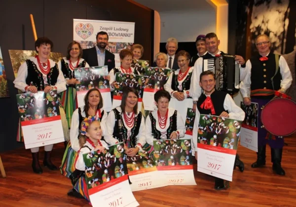 Zespół ludowy w tradycyjnych strojach prezentuje kalendarze na rok 2017 podczas spotkania Powiatu Płockiego.