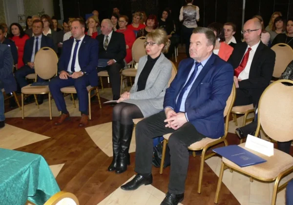 Uczestnicy konferencji „W małej ojczyźnie – przeciwko cywilizacji przemocy” siedzą w sali podczas wydarzenia, ubrani w formalne stroje.