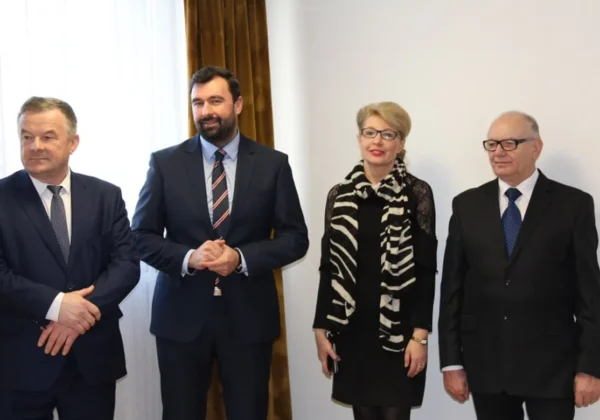 Cztery osoby w formalnych strojach stoją razem podczas Wigilii w Starostwie.