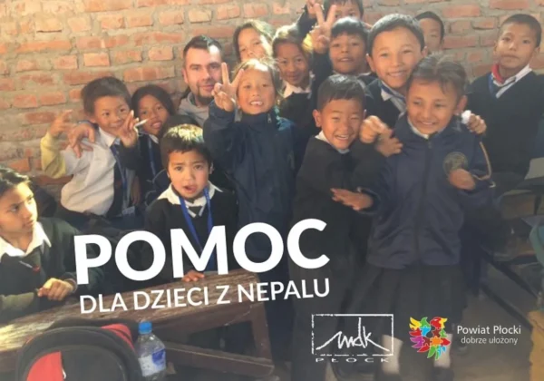 Grupa dzieci z Nepalu w szkolnych mundurkach uśmiecha się i pozuje do zdjęcia podczas zbiórki pomocy.