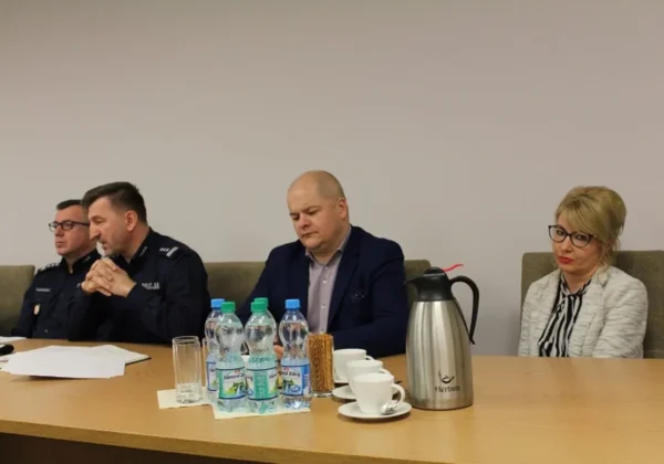 Czterech uczestników spotkania, w tym dwóch policjantów w mundurach, siedzi przy stole podczas konferencji podsumowującej miniony rok.