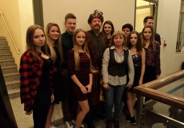 Grupa uczniów Zespołu Szkół im. St. Staszica w Gąbinie wraz z opiekunami stoi na szkolnym korytarzu, prezentując stroje i przygotowując się do filmowej przygody.