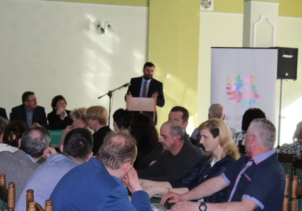 Na zdjęciu starosta z radnymi przemawia z mównicy podczas spotkania z liderami gminy Nowy Duninów w sali konferencyjnej.