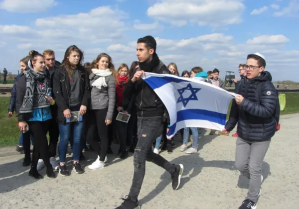 Grupa uczniów z ZS im. Leokadii Bergerowej podczas Marszu Żywych trzymająca flagę Izraela.