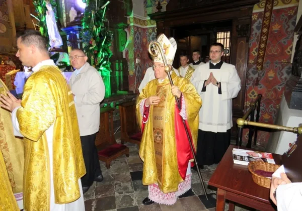 Biskup Roman Marcinkowski w złotej ornacie z pastorałem prowadzi modlitwę podczas uroczystości dziękczynnych w kościele, otoczony duchownymi.