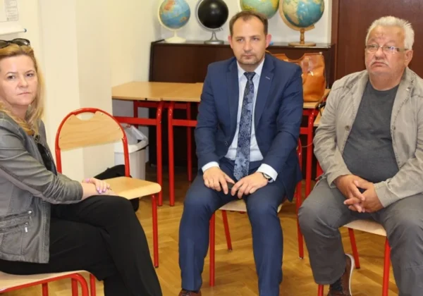Trzy osoby siedzą na czerwonych krzesłach w sali konferencyjnej, a w tle widać globusy — zdjęcie z ogólnopolskiej debaty „Jak wykorzystać potencjał Wisły?”.