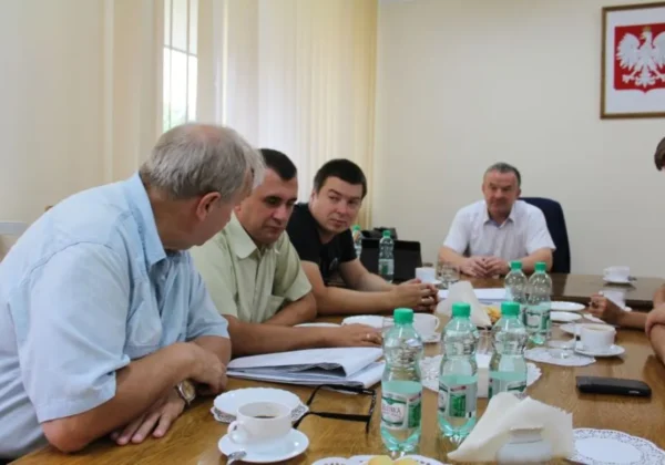 Grupa mężczyzn w sali konferencyjnej omawia kolejne inwestycje drogowe w Gminie Brudzeń Duży.