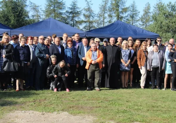 Duża grupa ludzi stoi na trawie przed niebieskimi namiotami podczas finału Kuchennych Rewolucji w Męczeninie.