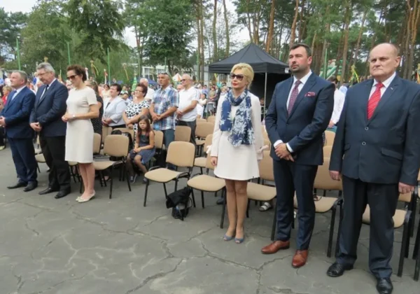 Uczestnicy Dożynek Gminno‑Dekanalo‑Parafialnych w Koszelówce 2017 stoją na otwartym placu, ubrani w eleganckie stroje, w otoczeniu ustawionych krzeseł i zgromadzonych gości.