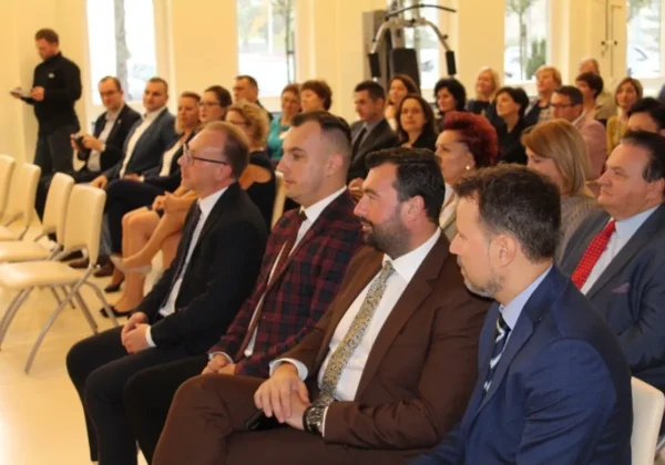 Grupa osób w eleganckich garniturach siedzi w sali konferencyjnej podczas spotkania dotyczącego dofinansowania MWOMP o wartości prawie 3 mln zł.